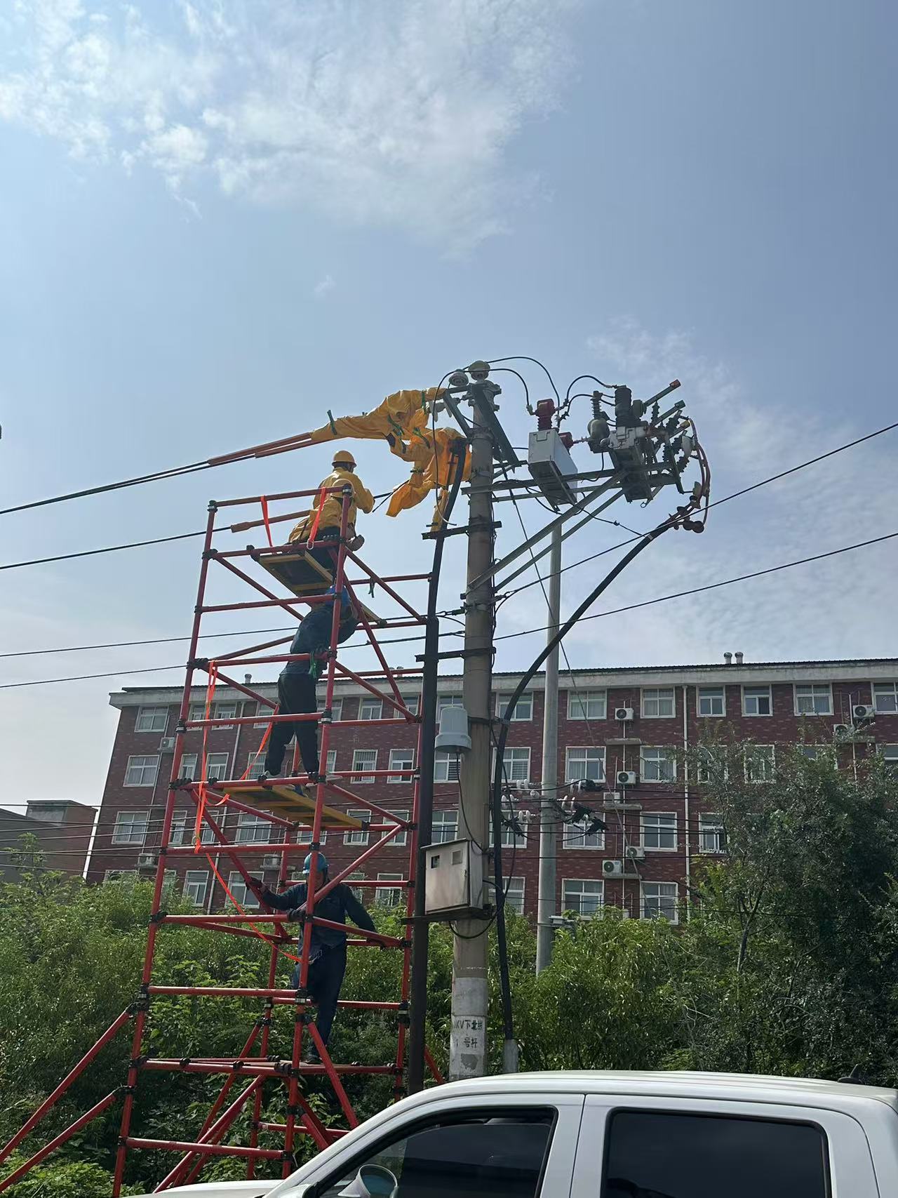 Technicians maintaining high-voltage power supply line equipment
